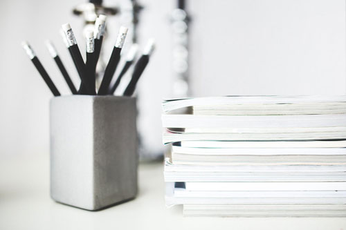 stack of forms and pencils in a pencil holder